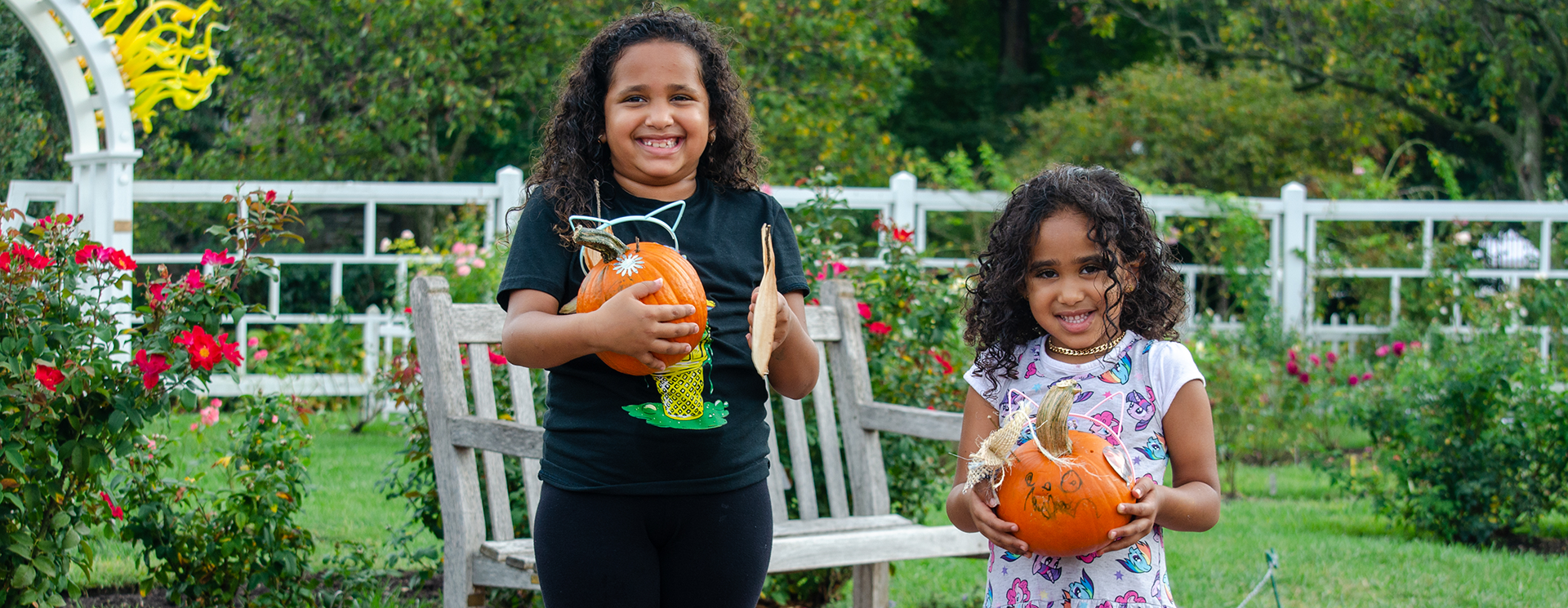 two girls holding pumpkins